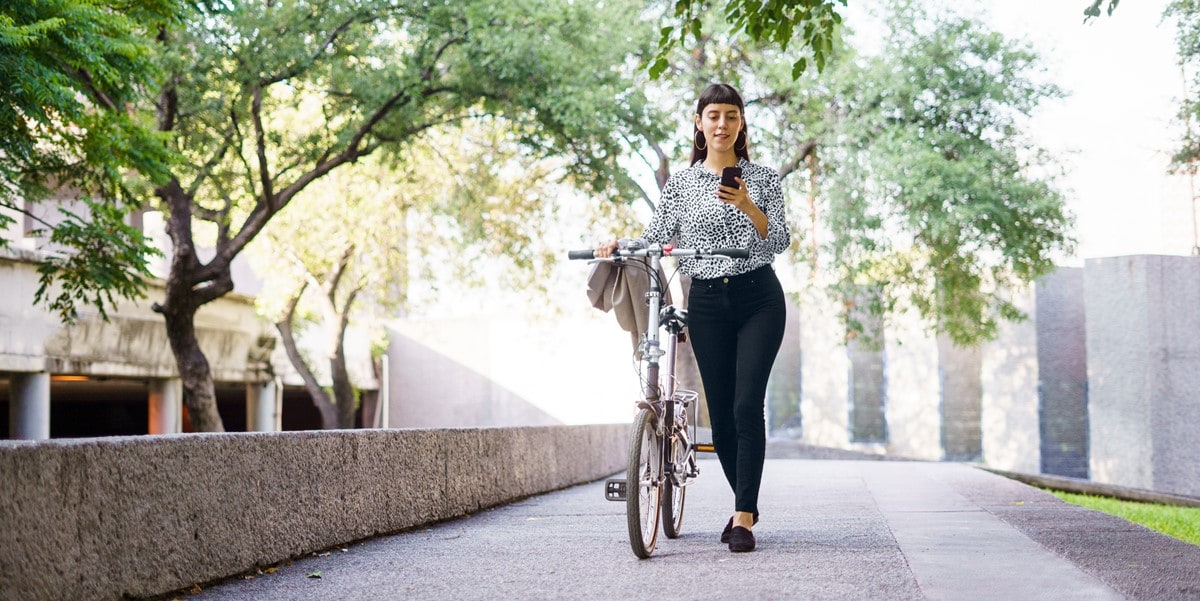 woman walking outside with bicycle