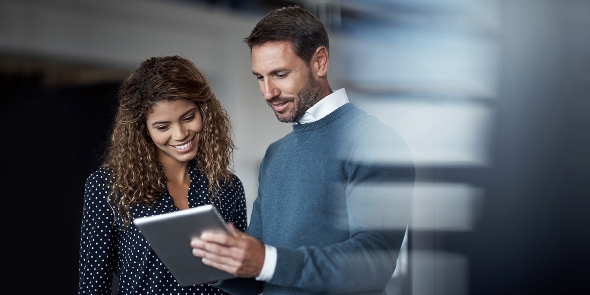 two professional in office reviewing a document