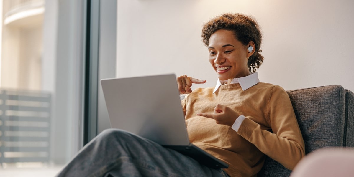 mujer en oficina trabajando en laptop, junta virtual