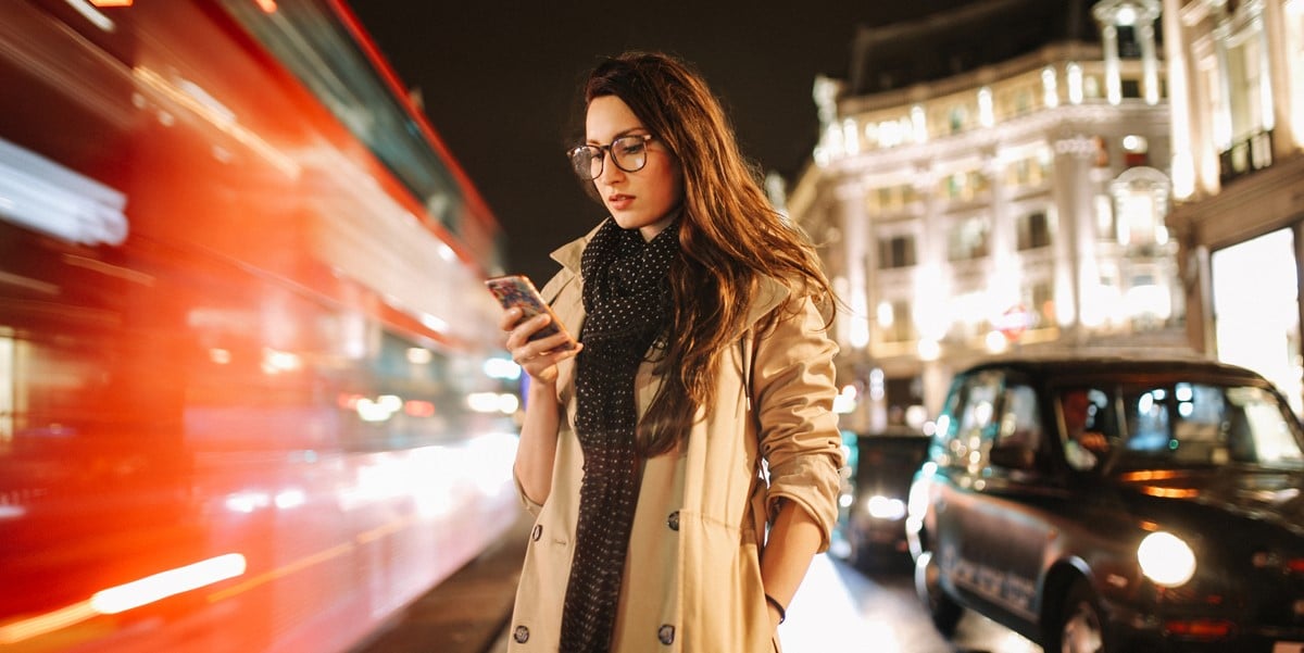 woman traveling, in city, looking at cell phone